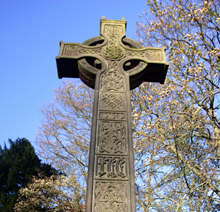 Celtic Cross in spring sunlight surrounded by trees