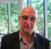 David Malouf, writer, with green trees behind him