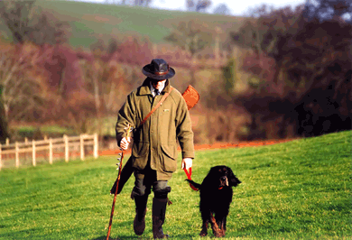 Brit walk home from shoot in the country with his dog