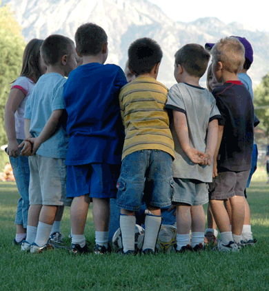 Children huddling before soccer