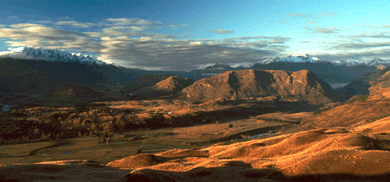 Beautiful New Zealand scene with snow-capped mountains and ruddy plains