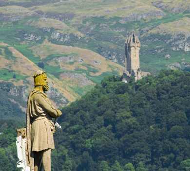 Statue of Robert the Bruce overlooking castle and wild country