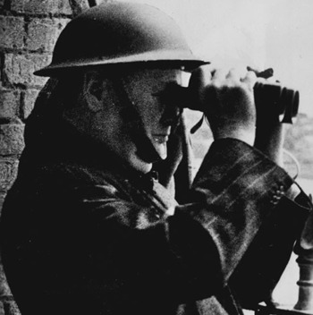 Winston Churchill in helmet looking through binoculars