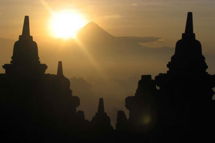borobudur silhoutted against sun