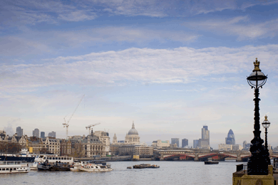 London viewed from the embankment with old London lamps, St. Paul's Cathedral and many ancient and modern buildings visible across the Thames River
