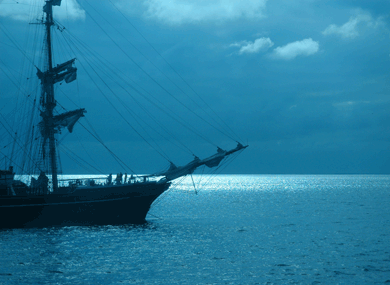 Tall ship at port under moonlit skies