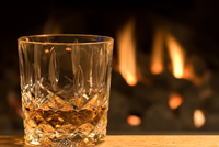 Glass of whisky and fire in hearth