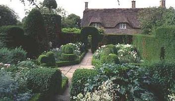 Garden 'room' filled with blossoms at Hidcote; manor house in distance